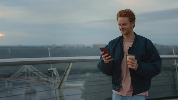 Man Walking on Street with Coffee and Smartphone