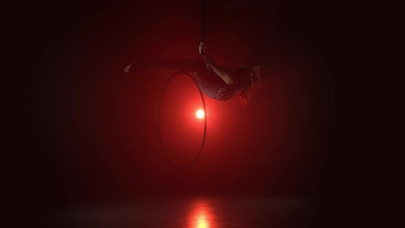 Aerial Acrobat in the Ring A Young Girl Performs the Acrobatic Elements in the Air Ring on Red