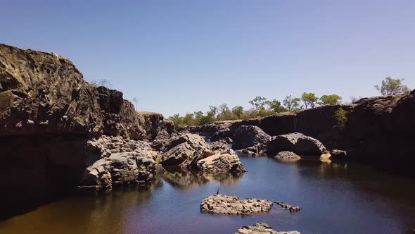 Drone flying above and in between rocks as it flys through a rocky gorge. Location Copperfield Gorge