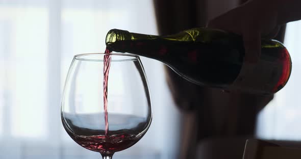 Closeup of Filling Wine Glass with Red Wine in Super Slow Motion