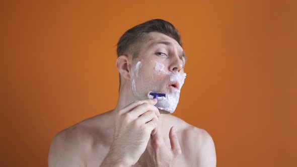 Handsome Man with White Foam on His Face, Isolated Background, Bare Chest, Shaves His Beard