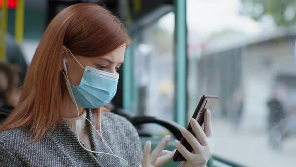 Woman Wearing Headphones Wearing Medical Mask and Gloves Uses Mobile Phone To Protect Against