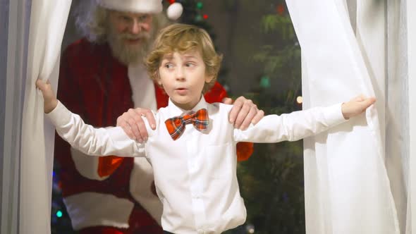 Portrait of Surprised Boy Looking Out Window As Santa Clause Entering Living Room Surprising Kid