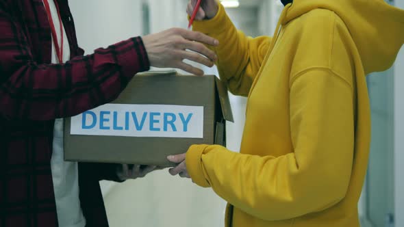 A Lady Pays By Card for a Delivery of a Parcel