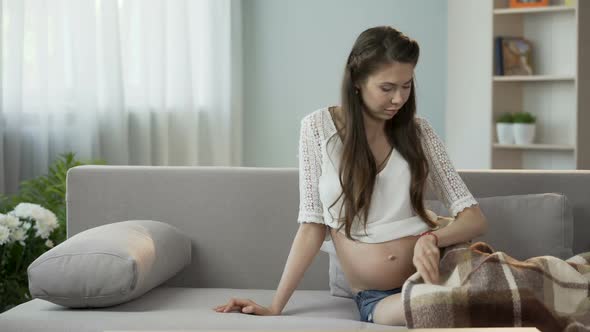 Young Pregnant Lady Putting Herself Down to Rest, Holding Teddy Bear, Future Kid