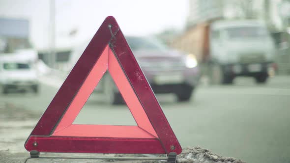 Warning Sign "Red Triangle" on the Road. Close-up. Crash. Car Breakdown