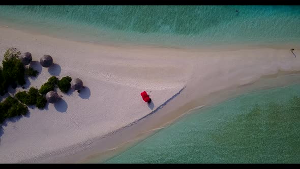Aerial drone shot landscape of marine coastline beach voyage by blue water with clean sand backgroun