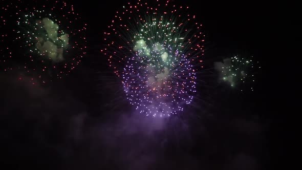 Colorful Fireworks Explode in Night Sky Spreading Smoke