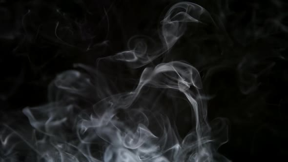 Thin Cigarette Smoke Lifts Up On A Dark Background