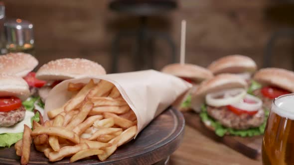 French Fries and Burgers Rotating on a Wooden Board