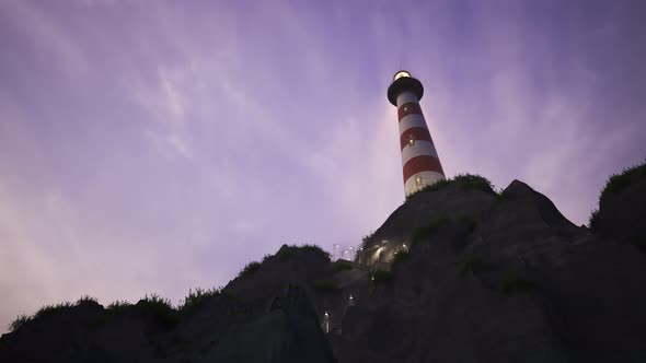 Lighthouse light spinning around. Tall tower standing on the small island.