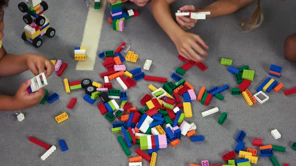 Hand of Kids Playing Toy Constructor on the Floor