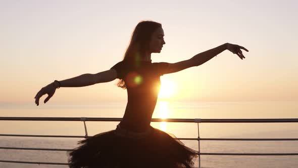 Beautiful Scene of a Dancing Ballerina in Tutu and Pointe Near Ocean or Sea at Sunrise or Sunset