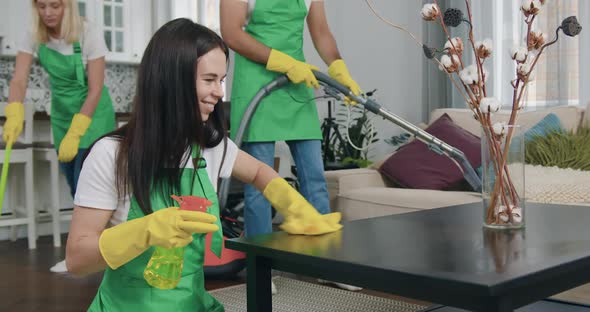 Woman from Cleaning Company Wiping Table with Microfiber Rag and Detergents