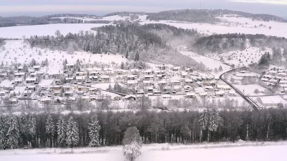 Smooth winter pullback drone shot from a line of snow covered bare trees with a wide view at a dream