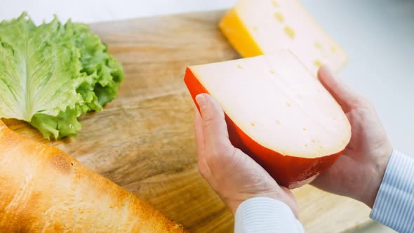 The Woman Holds in Her Hands a Piece of Cheese with Holes