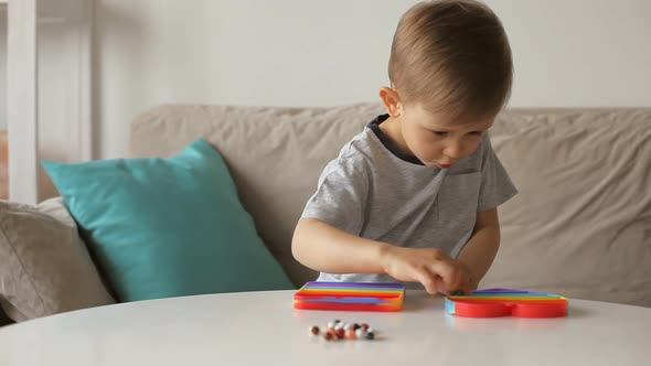 Motor Skills Training Child Playing with Antistress Pop It Toy and Spreads Beads