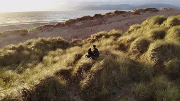 Young Couple Enjoy the Sunset Over the Ocean – Aerial Drone Footage