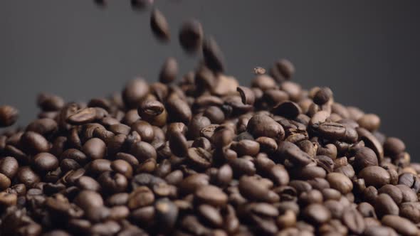 Fresh Coffee Grains Spilling on Pile Close Up