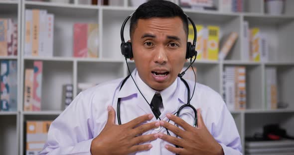 Doctor with headset making conference call and looking at camera