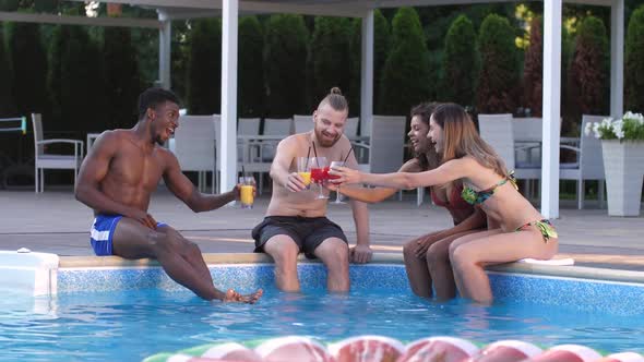 Happy Diverse Friends Drinking Juice on Pool Side