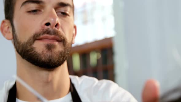 Male hairdresser cutting a womans hair with scissor