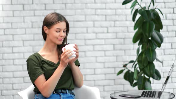 Relaxed Woman Drinking Hot Beverage Enjoying Break During Work