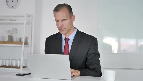 Portrait of Smiling Middle Aged Businessman Looking at Camera