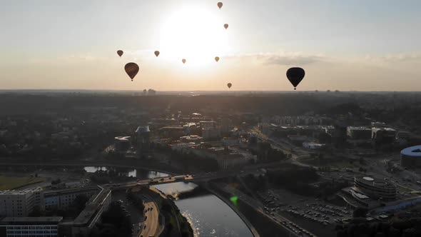 Flying Away From the Colourful Pack of Hot Air Balloons which Flies Above the City and River