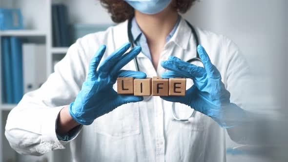 Medic Woman Holding The Word Life. Holds The Word Life In English