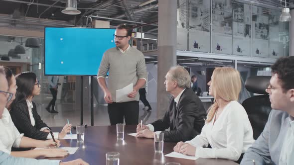 Young Attractive Businessman Showing Presentation To His Colleagues