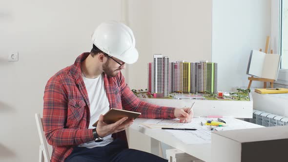 Young Man Making Building Model in Office.