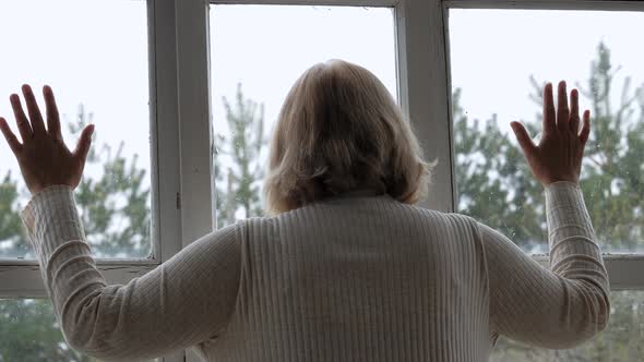 Woman Puts Her Hands Hopefully On The Window Glass