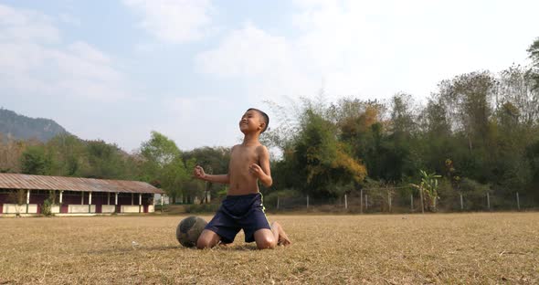Rural Boy Celebrating With Old Soccer Ball
