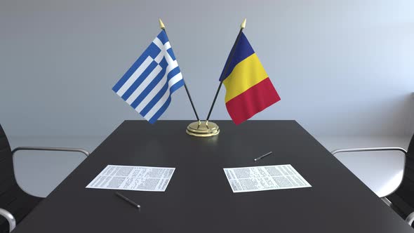 Flags of Greece and Romania and Papers on the Table