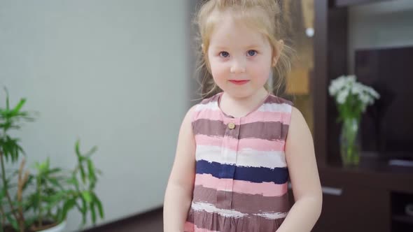 a Funny Little Girl Takes a Photo on a Little Pink Toy Camera