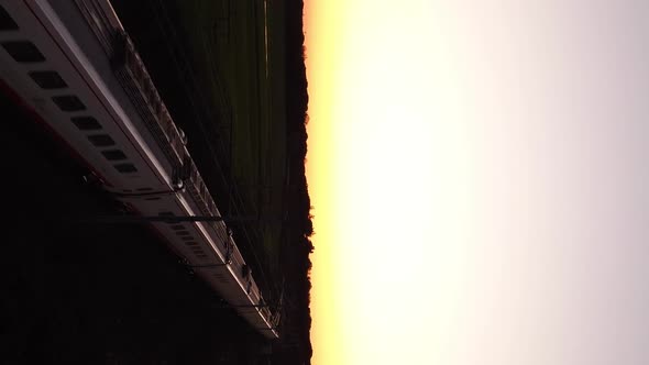 Vertical video of train passing in the sunset