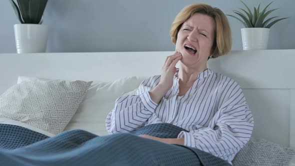 Toothache Old Senior Woman with Tooth Pain Sitting in Bed