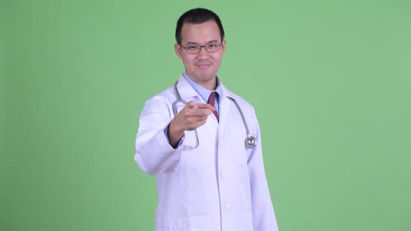 Happy Asian Man Doctor with Eyeglasses Pointing at Camera