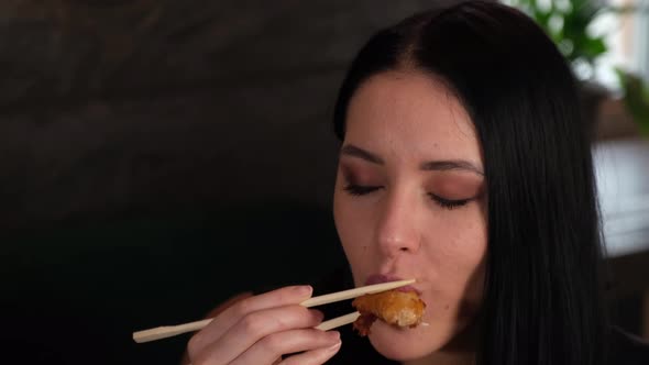 Beautiful Brunette Girl Eats Tempura with Chopsticks