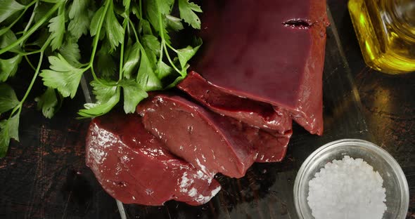 Sliced Raw Liver with Salt and Herbs on the Table
