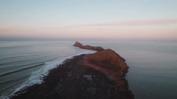 AERIAL: Worm's head during orange sunrise, Rhossili Gower, 4k Drone