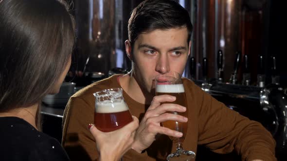 Handsome Man Enjoying His Beer, Drinking with His Girlfriend at the Pub