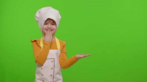 Child Girl Dressed Cook Chef in Apron Pointing at Right on Blank Space on Chroma Key Background