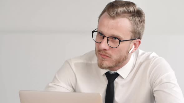 Portrait of Young Bearded Businessman Is Talking in Work Process at Table in Modern Office.