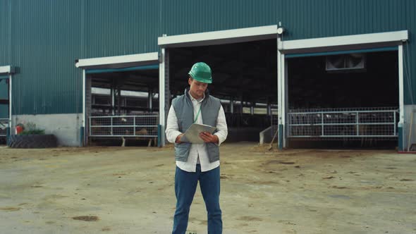 Agriculture Worker Writing Clipboard at Cowshed