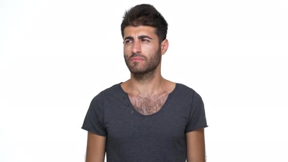 Caucasian Young Man Wearing Grey Tshirt Looking at Camera Expressing Misunderstanding Throwing Up