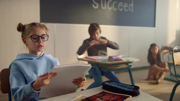 Cute Girl Sitting at Desk at School