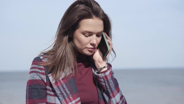 Gorgeous Caucasian Woman Talking on the Phone with Calm River at the Background. Portrait of