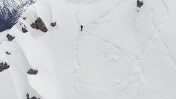 Aerial View of a Backcountry Skier Rides Freeride on a Steep Slope. Professional Ski Extreme in the